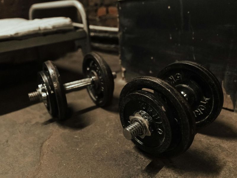 Detail of a dumbbell on a dark gym floor
