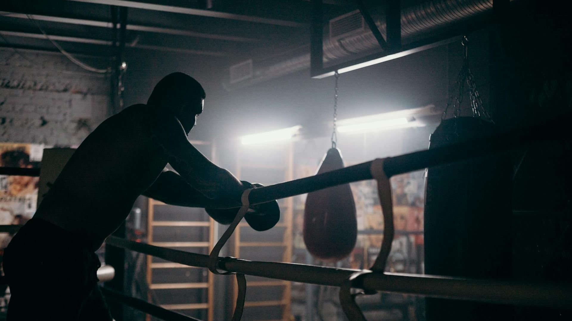 Man focused on training in a dark atmospheric gym environment